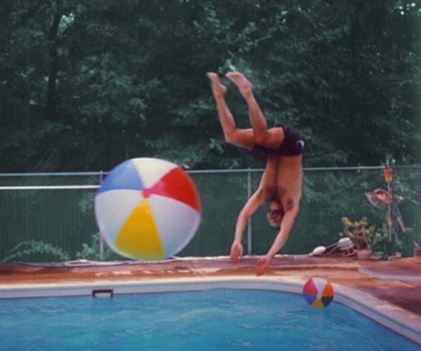 Marty jumping with a ball in the pool