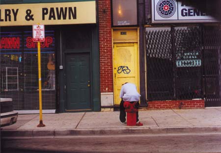 man sitting on a fire hydrant