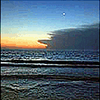 the beach just past sunset with the moon
